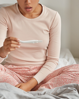 femme qui tient dans les mains un test de grossesse